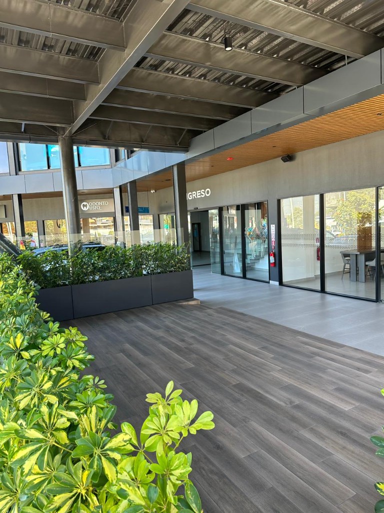Terraza cubierta con jardineras y barandas en vidrio