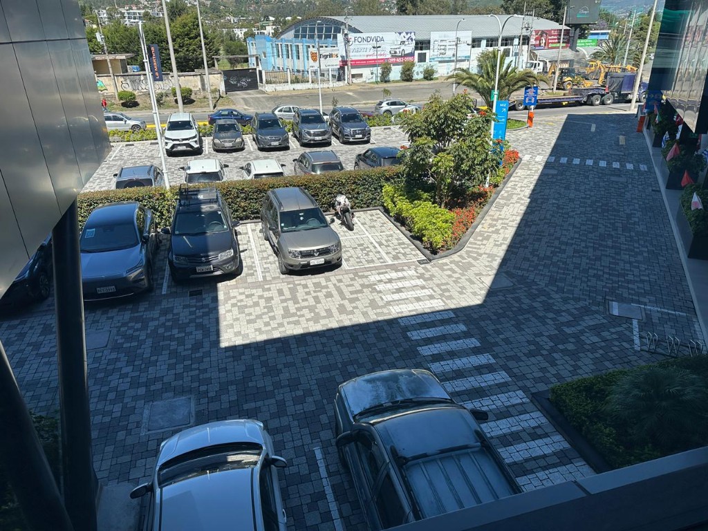 Vista desde la terraza hacia parqueaderos y entorno comercial